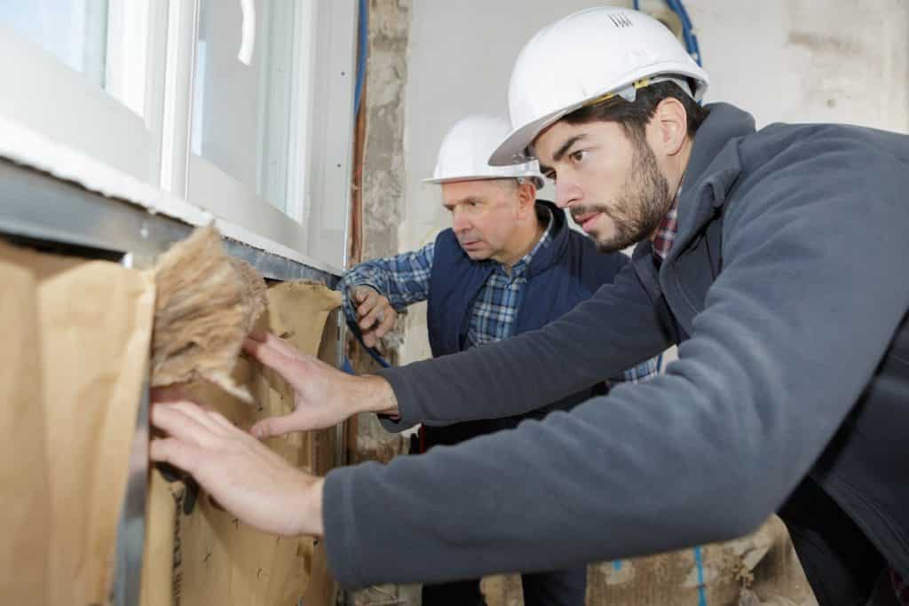 Workers Insulating House Walls