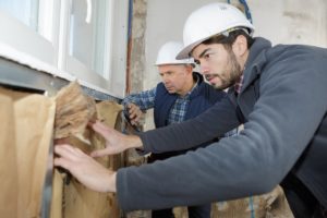 Workers Insulating House Walls